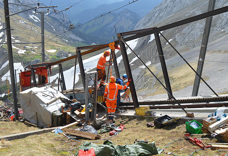 Mit Seilzügen wird die angehobene Wendeplatte entlang des Trägers zur Einbaustelle gezogen.